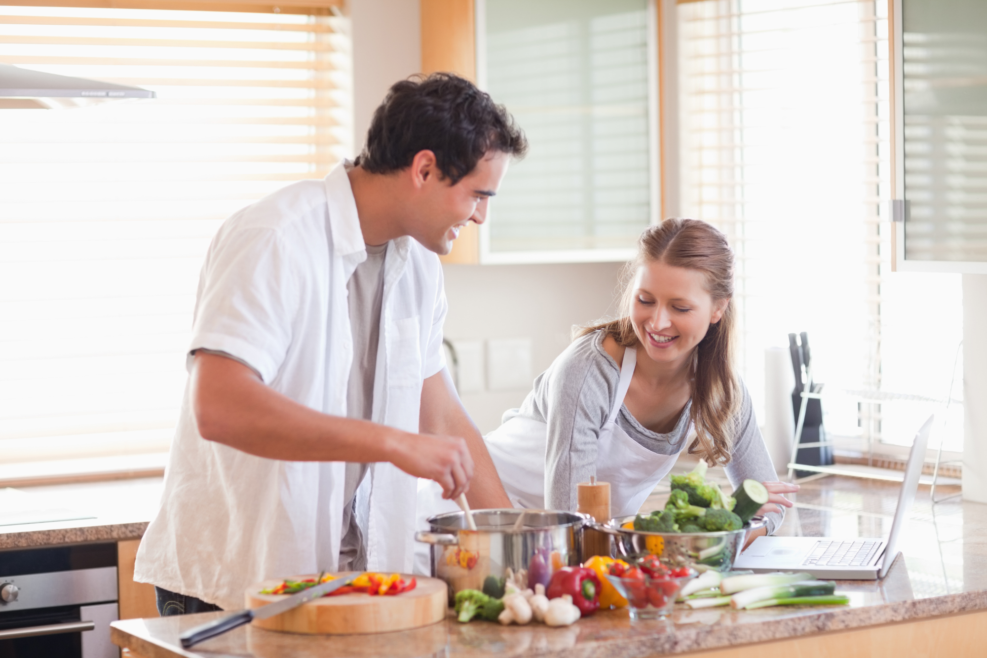 Готовим разом. Притирка в семье кухня. Сток фото рецепт. Couple looking at Kitchen. Человек смотрит рецепт.